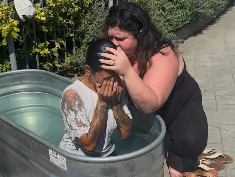 A woman embraces and prays over a man in the baptism tank at Jesus Festival Hamilton 2026