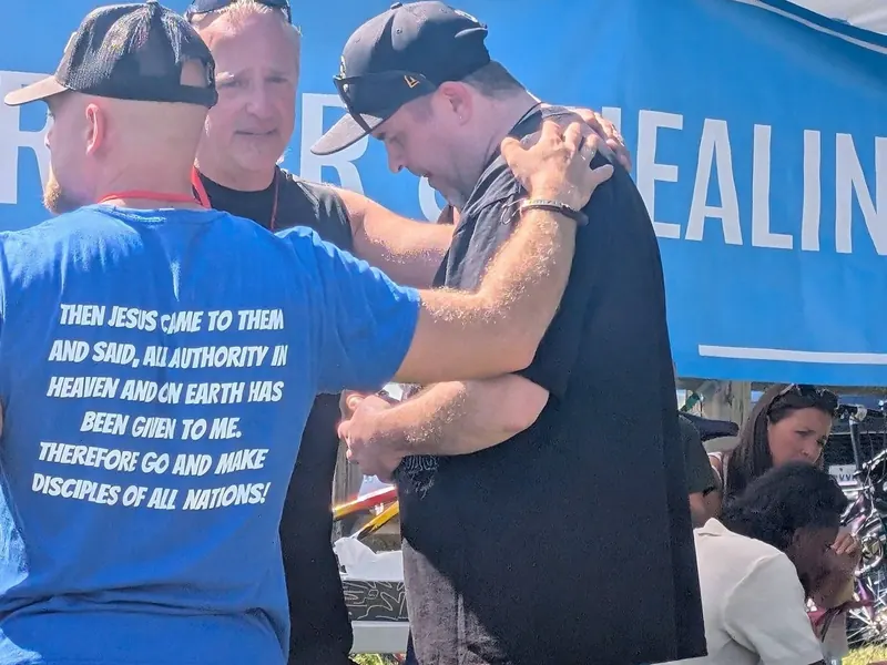 Two men pray over a festival guest at the prayer and healing tent at Jesus Festival Hamilton 2026